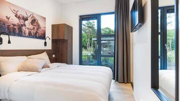 Een moderne hotelkamer met een groot bed, een wandgemonteerde televisie en uitzicht op de omgeving.