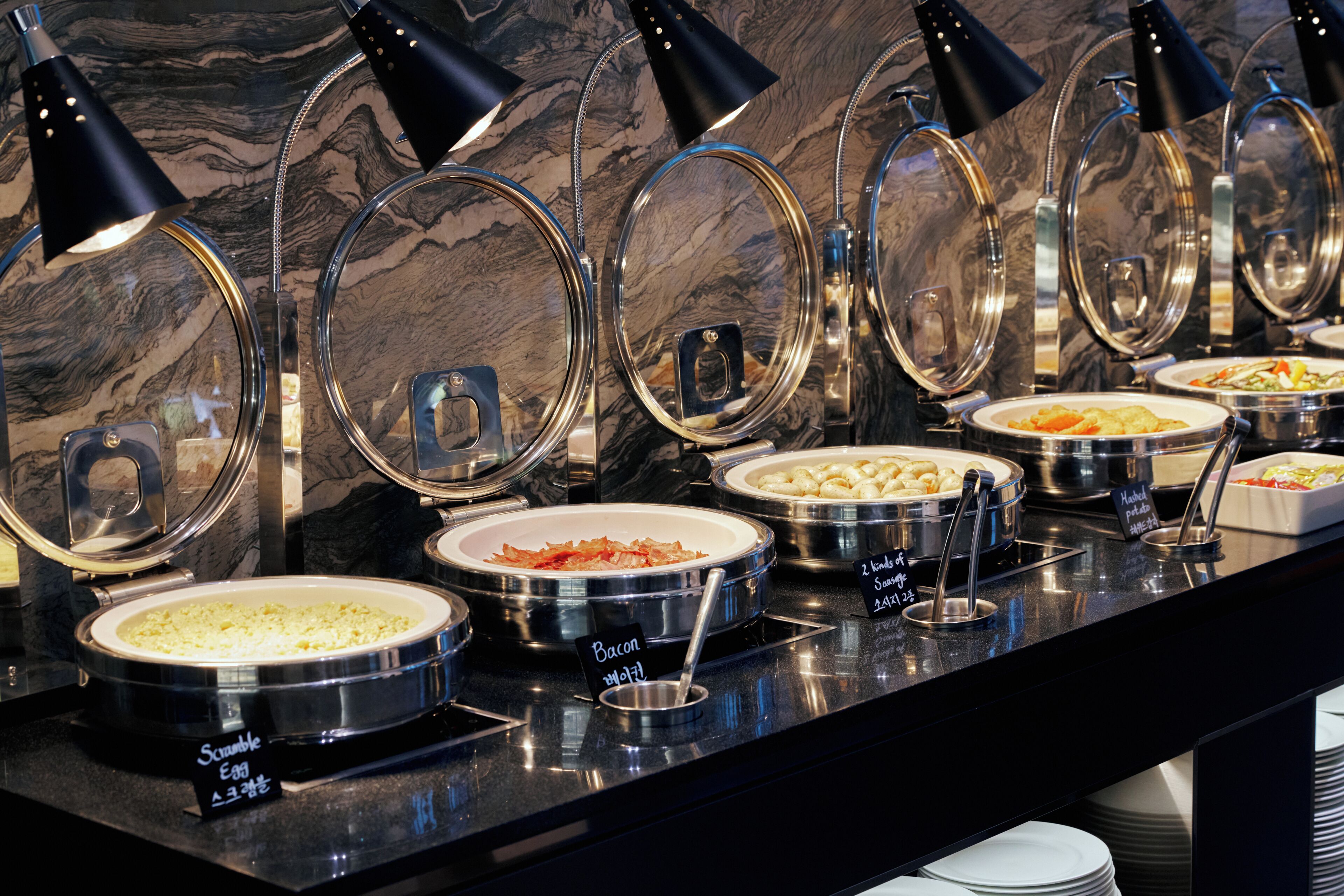 A buffet with various food options, each with a label indicating the dish name.