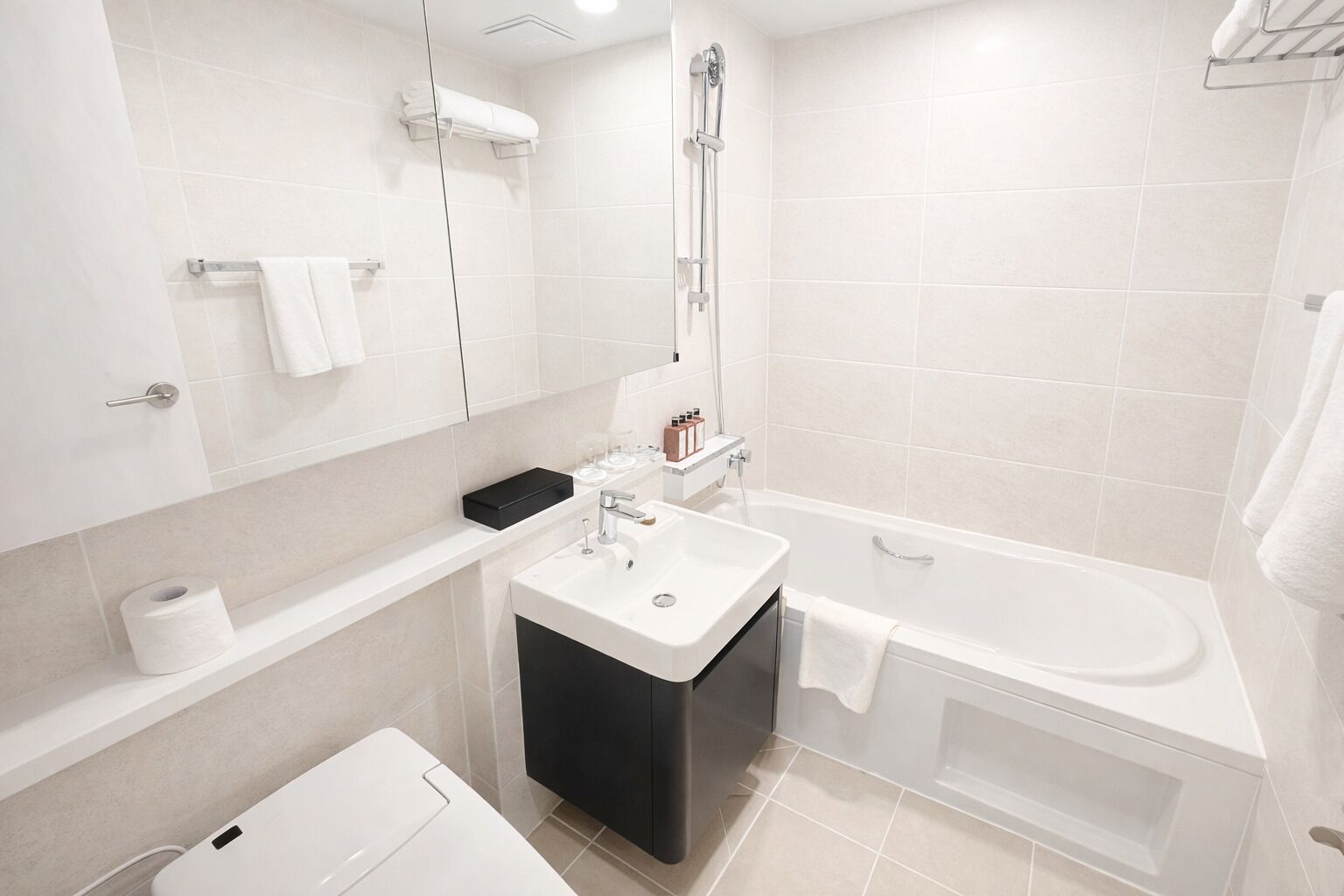 A modern bathroom with a white sink, a bathtub, and a shower.