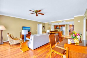 Habitación de hotel con sala de estar, mesa de comedor y kitchenette.