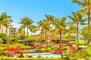 A resort with a pool area, palm trees, and a building with multiple balconies. - Honua Kai | Ocean View 7 BR, Sleeps 24 | Car Incl. w/ 6+ Nights | HKK ML-3269 by KBM (Lahaina)