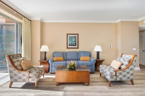 Una sala de estar con un sofá, dos sillones, una mesita de centro y dos lámparas.