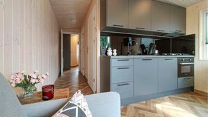 A modern kitchen with grey cabinets, a built-in oven, and a coffee machine. - 2 bedroom lovely home in Heinkenszand (Heinkenszand)