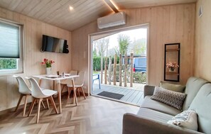 Ein modernes Interieur mit Essbereich, einer Couch und einem an der Wand befestigten Fernseher.