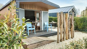 A modern house with a patio, outdoor seating, and a wooden deck. - 2 bedroom lovely home in Heinkenszand (Heinkenszand)