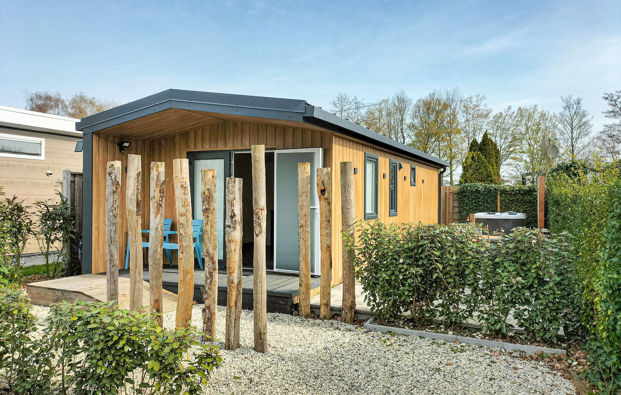 Een modern gebouw met een houten gevel, een deur en een raam.