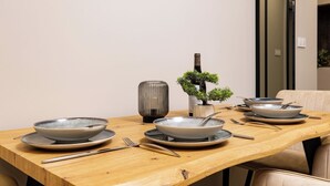 A dining table with plates, cutlery, and a bonsai tree. - A2 Modern 1-bed Apartment 1 (Plovdiv)