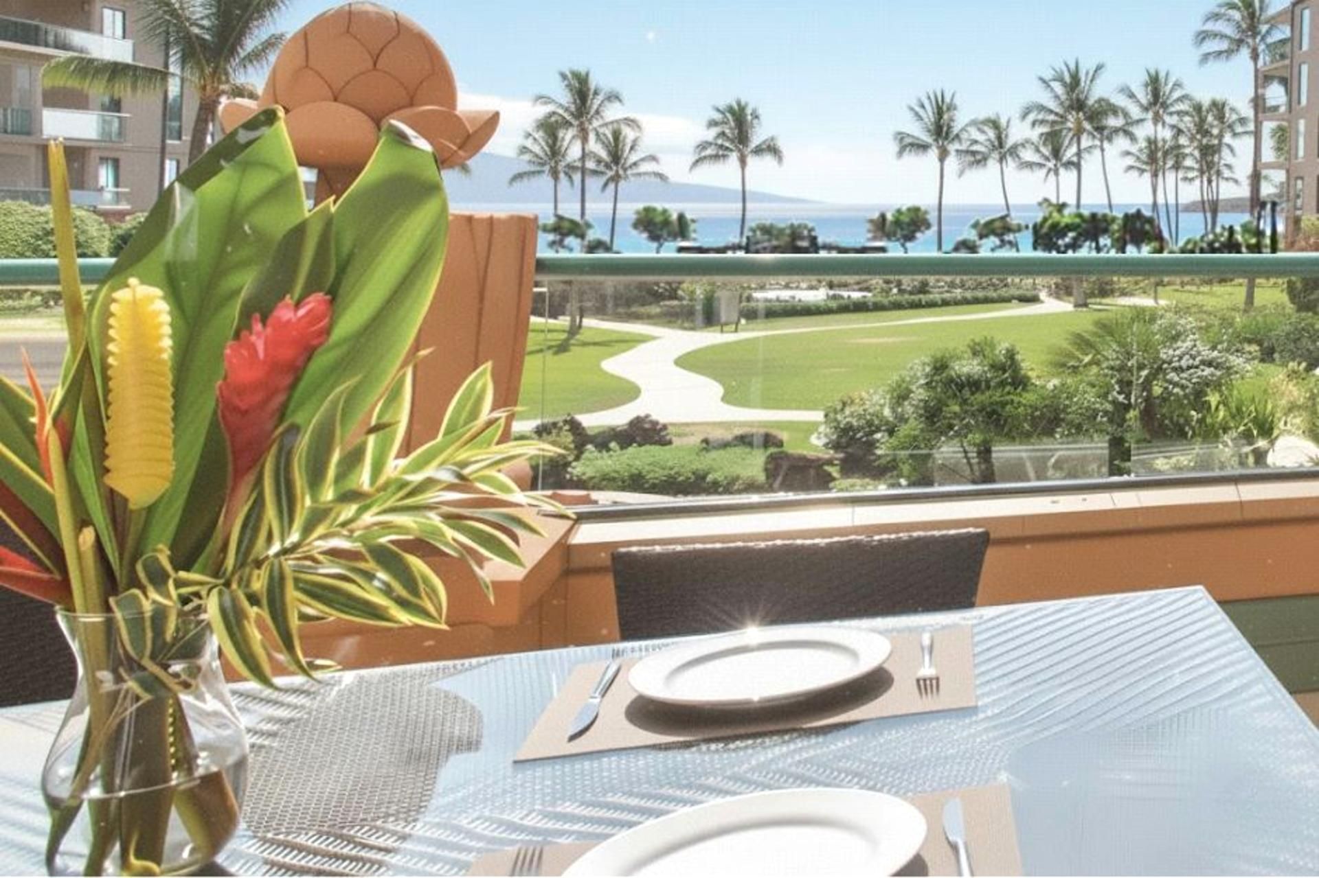 A dining table with a view of a landscaped garden and a beach.