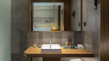 Une salle de bain moderne avec un grand miroir, un meuble-lavabo en bois et un lavabo encastré.