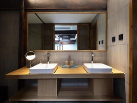 A modern bathroom with two sinks, a mirror, and a wooden vanity.