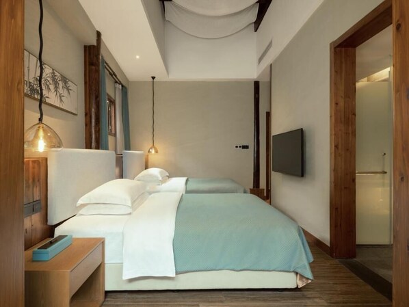 A modern bedroom with a bed, bedside tables, a TV, and a wooden door. - Hidden Moisture and Return (Huangshan)