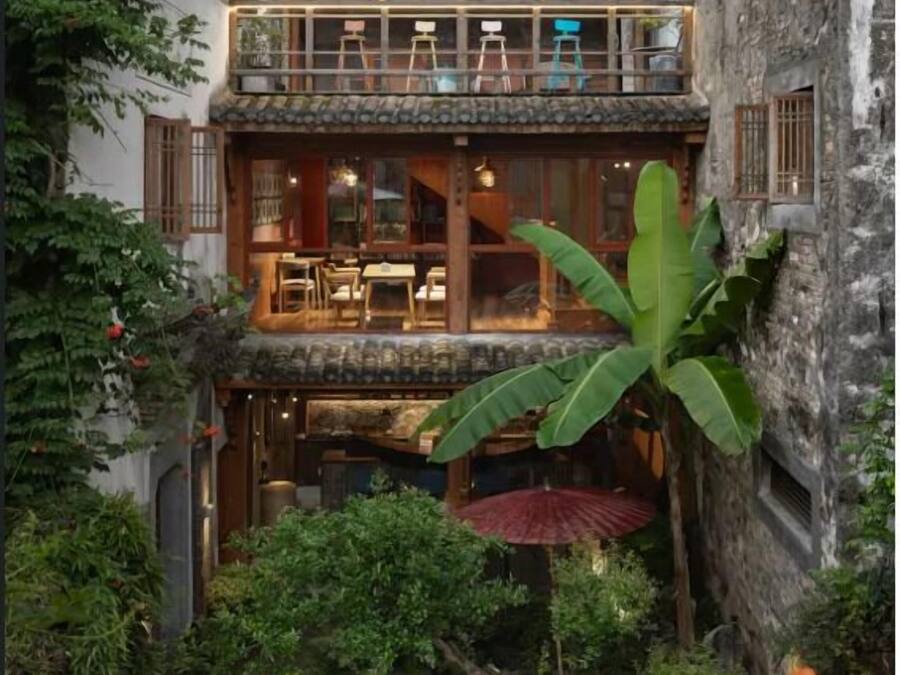 A traditional building with a balcony, a dining area, and a small garden with a water feature.