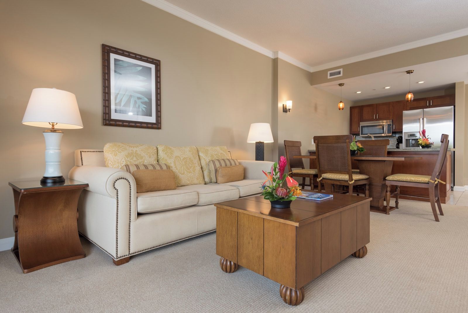 Une chambre d’hôtel équipée d’un canapé, d’une table basse, de chaises, d’une table à manger et d’un coin cuisine.