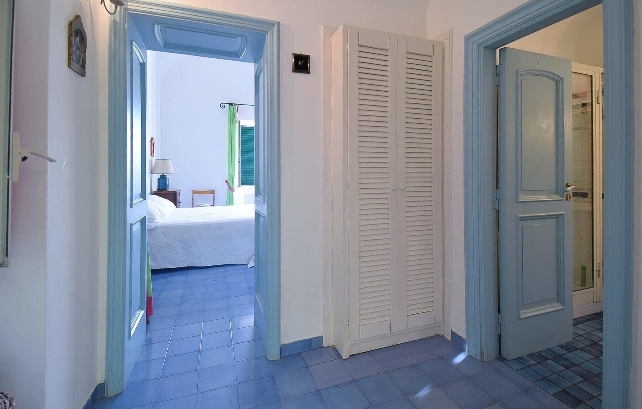 Ein Flur mit einem Bett, einem Kleiderschrank und einer Tür zu einem anderen Raum.