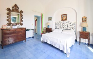 Une chambre à coucher comprenant un lit, une commode, un miroir et deux tables de chevet.