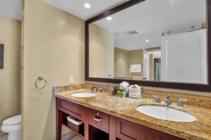 A bathroom with two sinks, a large mirror, and a towel rack. - Honua Kai | 4 FREE CARS | KBM Resorts | Wrap Around Lanai | 4 Units, 9 Bedrooms | HK ML-3371 (Lahaina)