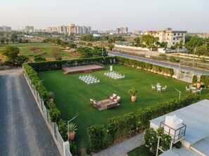 An outdoor venue with a stage, seating, and greenery.