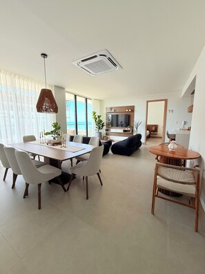 A modern living room with a dining area, a TV, and a view of the sea. - Morros Kai Luxe, Oceanfront, 8 PPL, Beach Access, Pool, Views (Cartagena)
