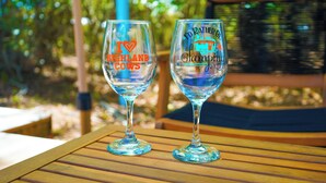 Two wine glasses on a wooden table with engraved text. - Pasture Bedtime Yurt (Middleburg)