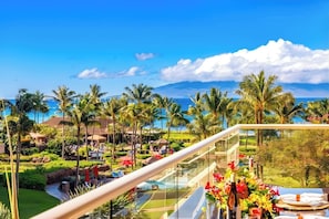 A resort with a pool, palm trees, and a view of the ocean. - Honua Kai | Ocean View 7 BR, Sleeps 20 | Car Incl. w/ 6+ Nights | HKK ML-3416 by KBM (Lahaina)