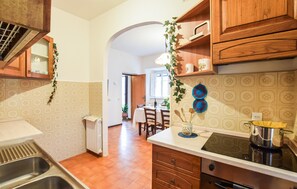 A kitchen with wooden cabinets, a built-in stove, and a dining area in the background. - Gorgeous home in Pascoso (Pascoso)