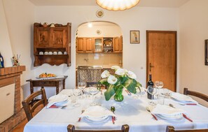 A dining room with a table set for four, a kitchen in the background, and a wooden door. - Gorgeous home in Pascoso (Pascoso)