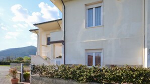 A two-story building with a balcony, a small window, and a number '32' on the wall. - Appartamento Casale Le Risaie (Vicopisano)