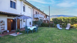 A residential property with a patio, outdoor seating, and a view of the mountains. - Appartamento Casale Le Risaie (Vicopisano)