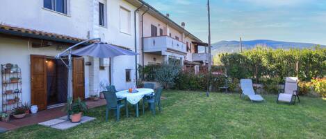 A residential property with a patio, outdoor seating, and a view of the mountains.