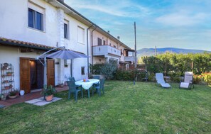 A residential property with a patio, outdoor seating, and a view of the mountains. - Appartamento Casale Le Risaie (Vicopisano)
