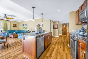 Une cuisine moderne avec des meubles en bois, des appareils en acier inoxydable et un îlot central.