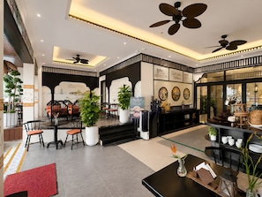 A hotel lobby with a reception desk, seating area, and a buffet sign. - Sujet Marina Da Nang Hotel by Haviland (Da Nang)