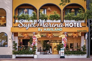 La façade d’un hôtel, avec une enseigne indiquant « Suzet Marina Hotel By Haviland » et le numéro « 22 » qui correspond à l’adresse.