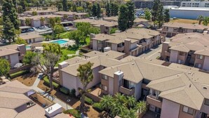 A residential area with apartment buildings, a swimming pool, and green spaces. - Spacious and Comfy 2-bedroom condo with AC near UC Riverside (Riverside)