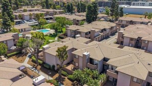 Zona residencial con edificios de apartamentos, piscina y espacios verdes.