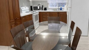 Una cucina moderna con mobili in legno, un tavolo da pranzo in vetro e un forno integrato.