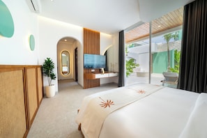 A modern hotel room with a large bed, a TV, a desk, and a view of the outdoors. -  Lomo Boutique Hotel, Uluwatu. (Pecatu)