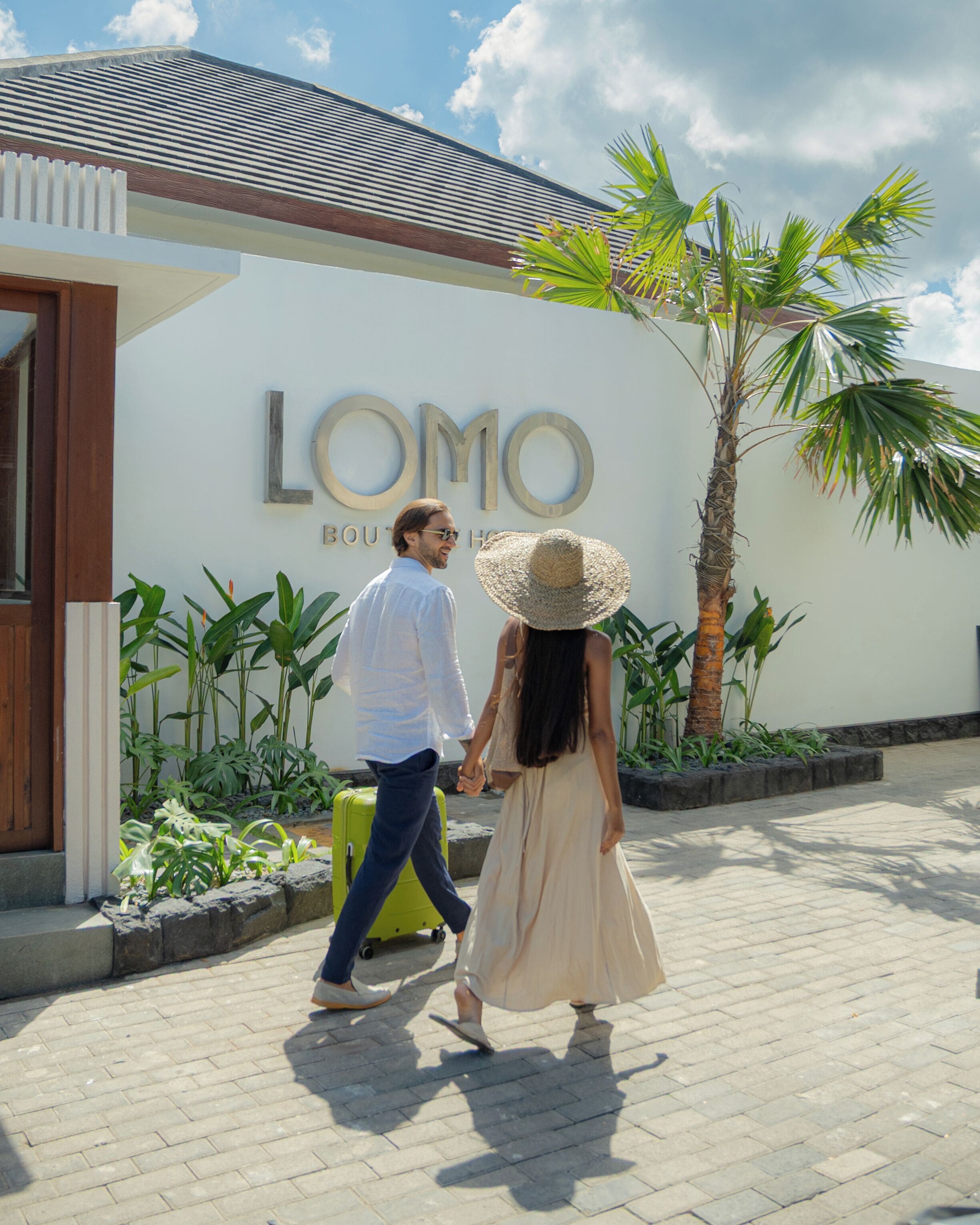 A couple walking in front of a building with 'LOMO BOUTIQUE' signage.