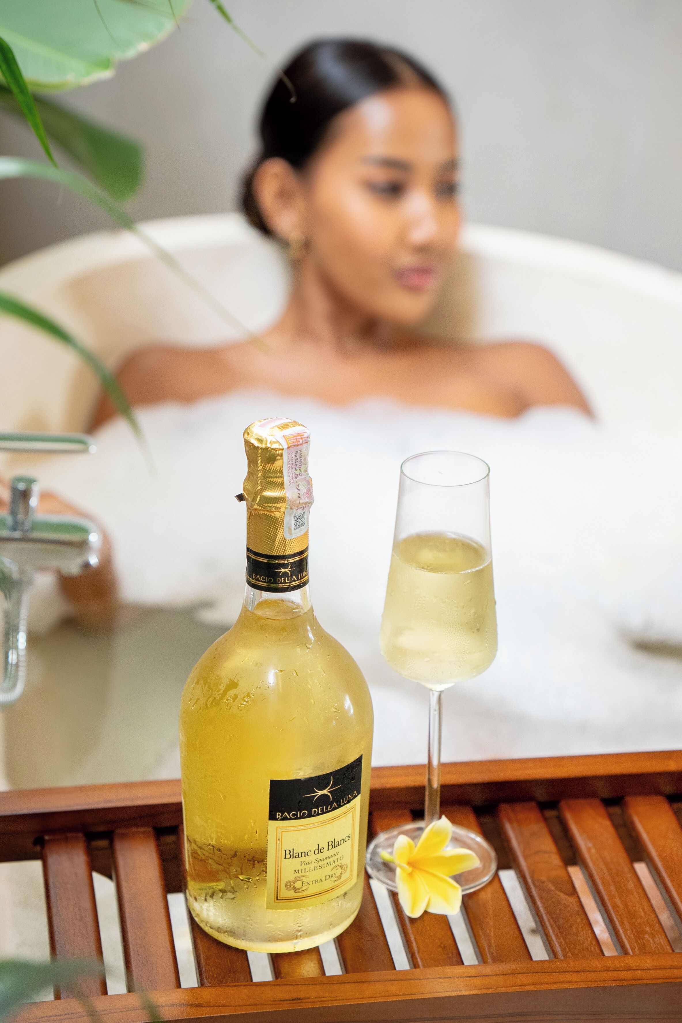 Una botella de vino Blanc de Blancs y una copa sobre una bandeja.