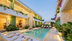 A modern hotel with a pool, lounge chairs, and greenery. - Lomo Boutique Hotel & Villas, Uluwatu (Pecatu)