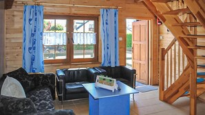 Een houten interieur met een bank, een tafel en een trap.