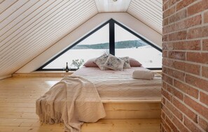 A cozy attic bedroom with a bed, pillows, and a blanket. - Stunning home in Dmuchowo with WiFi (Dmuchowo)