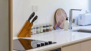 Una cucina con fornello, forno, lavello e diversi utensili da cucina.