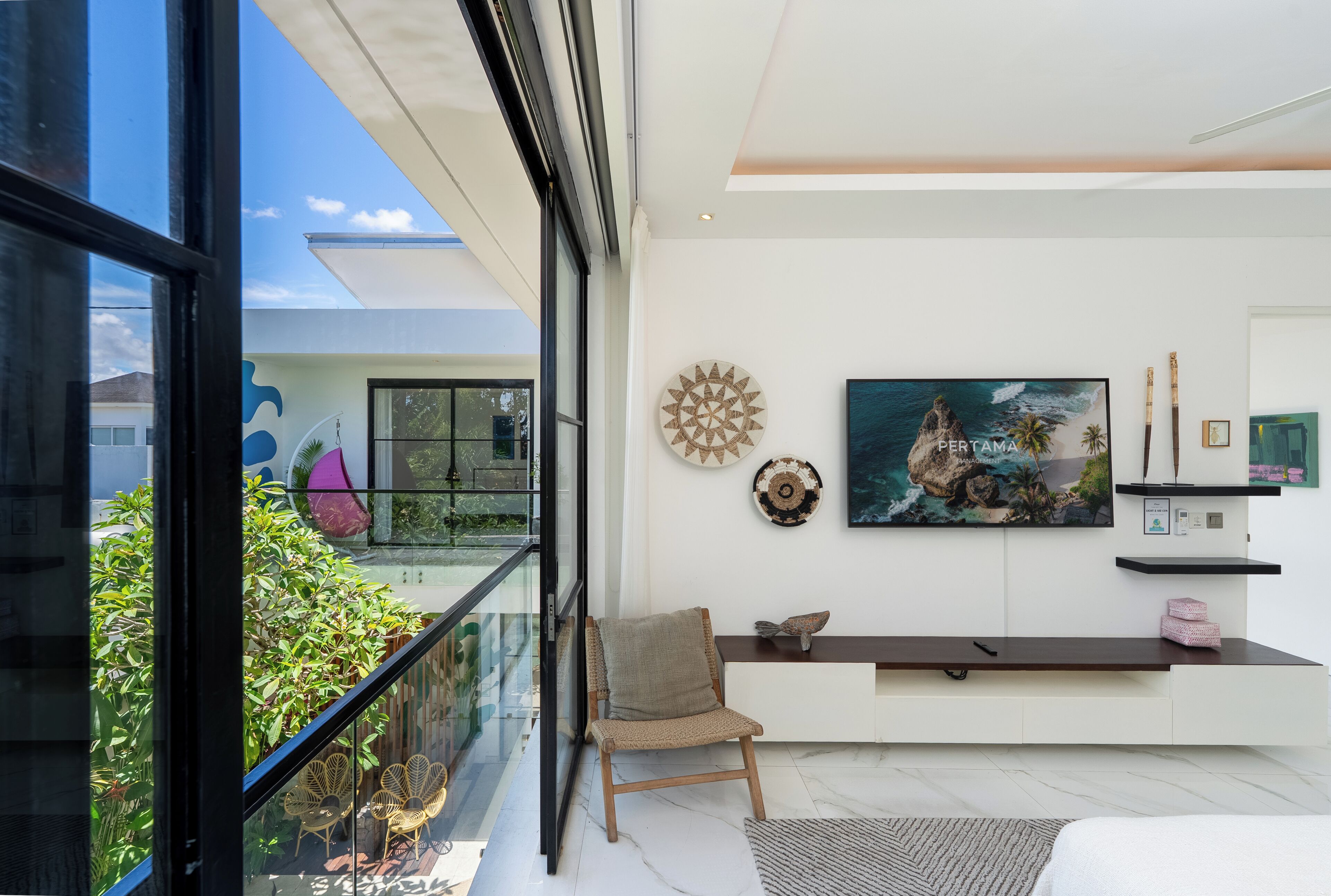 Un intérieur moderne avec un balcon, une grande fenêtre et un tableau au mur.