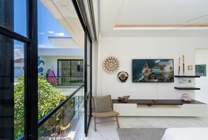 Un interior moderno con un balcón, un ventanal grande y un cuadro en la pared.