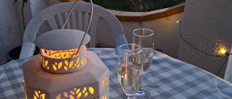 A checkered table with a lantern, glasses, and a tray of chocolates.
