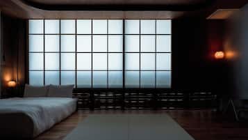 A modern bedroom with a large window, a bed, and a small table.