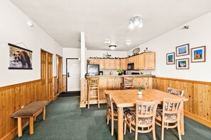 Eine Küche mit Holzausstattung, einem Esstisch mit Stühlen und einer Bank.