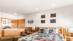 Une chambre dotée d’un grand lit, d’une baignoire en bois et d’une armoire en bois.