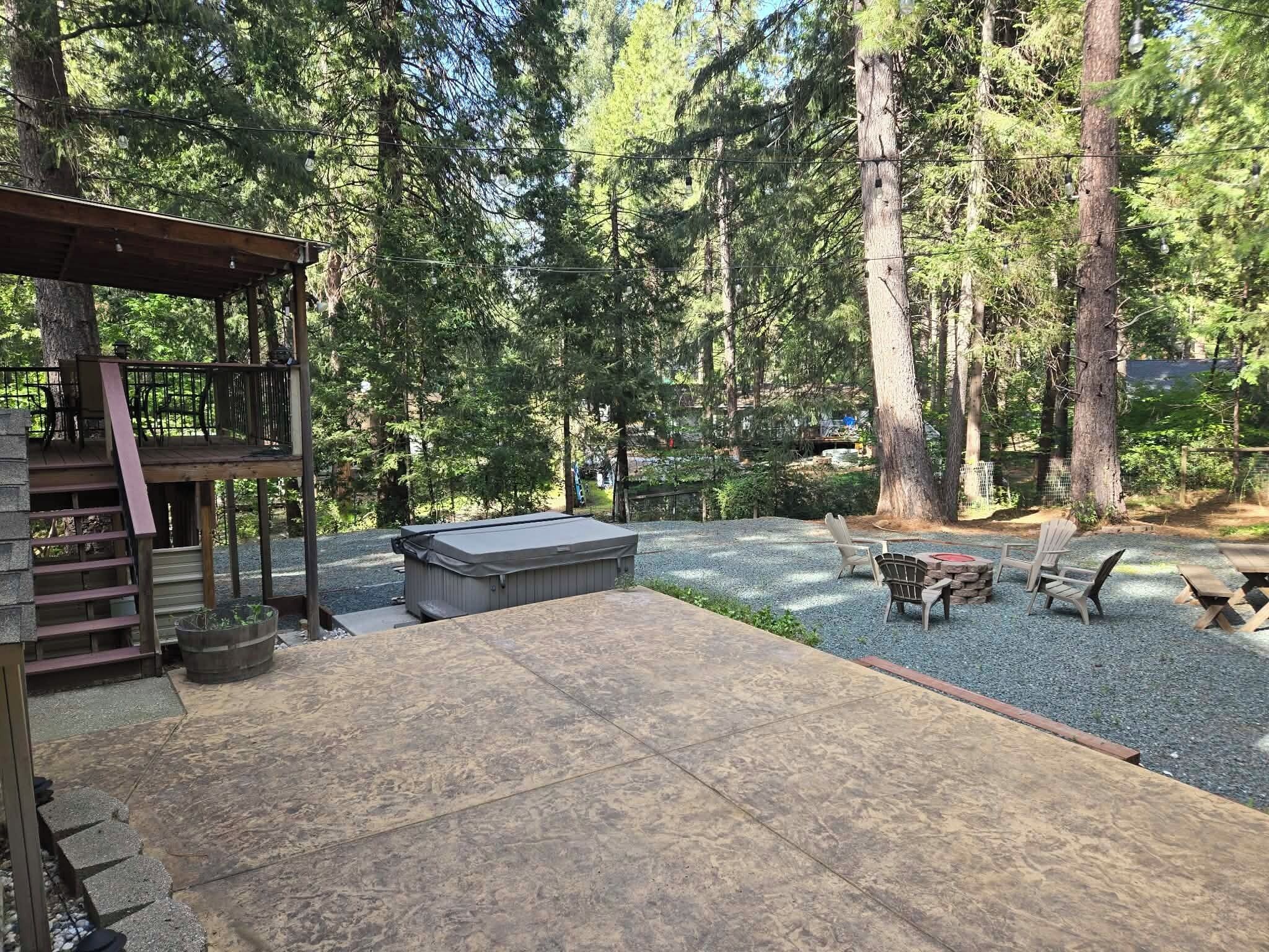 Une terrasse avec coin salon extérieur, un jacuzzi et un espace recouvert de gravier.
